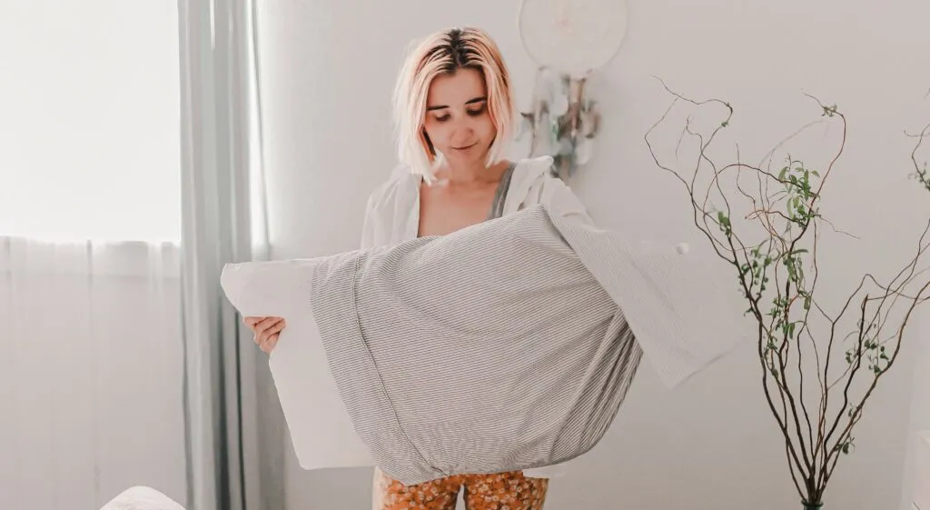 Frau bezieht Kissen mit neuem Bezug